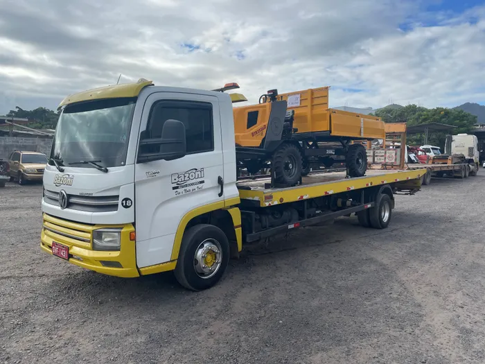 Caminhão plataforma Bazoni transportando rolo compactador